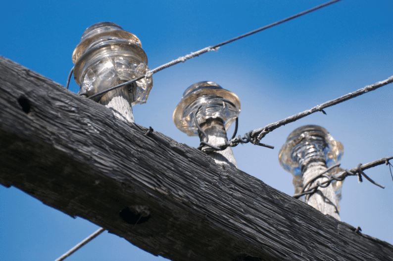 vintage glass insulators on telephone pole wires